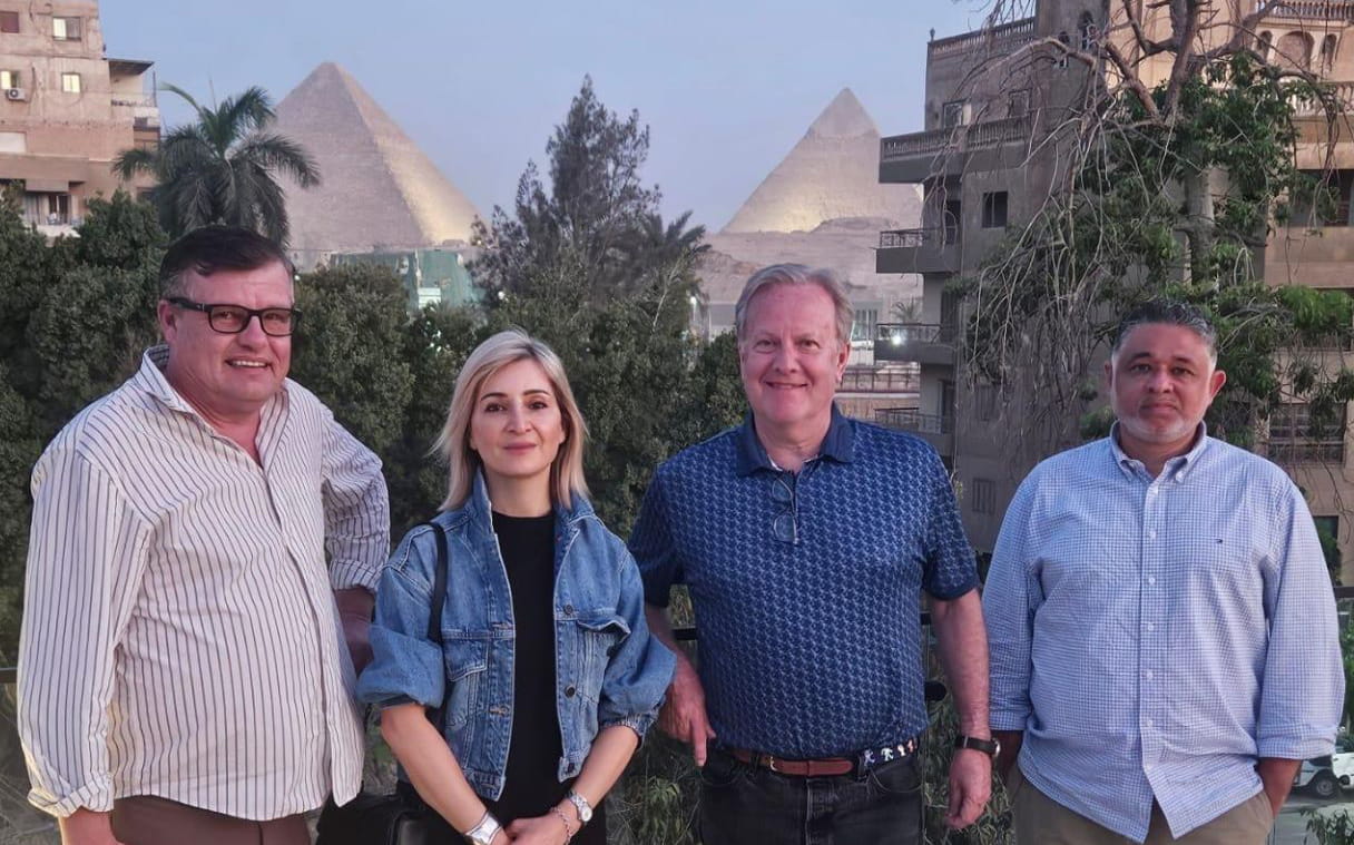 Four members of the Baker Global Advisory team standing in front of pyramids in Egypt