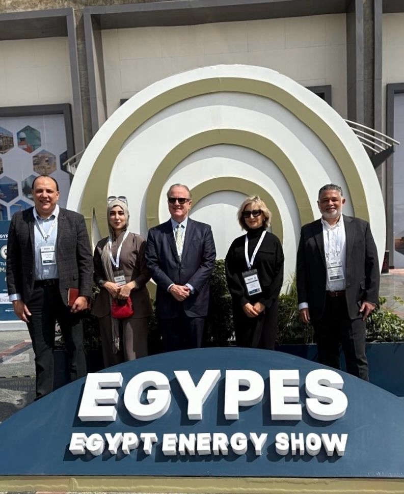 Five people in business attire stand in front of an EGYPES Egypt Energy Show sign with a decorative backdrop outdoors during daylight, representing Baker Global at the event.